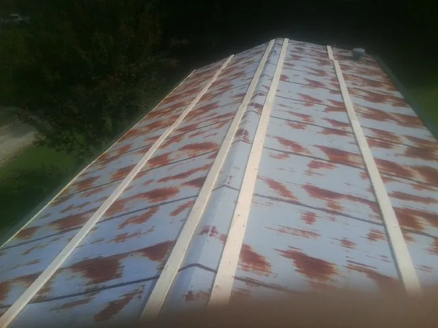 Rusted metal roof panels with new wood purlins before replacement — Storm Damage Roof Repair in Lattimore by Roofing Brothers