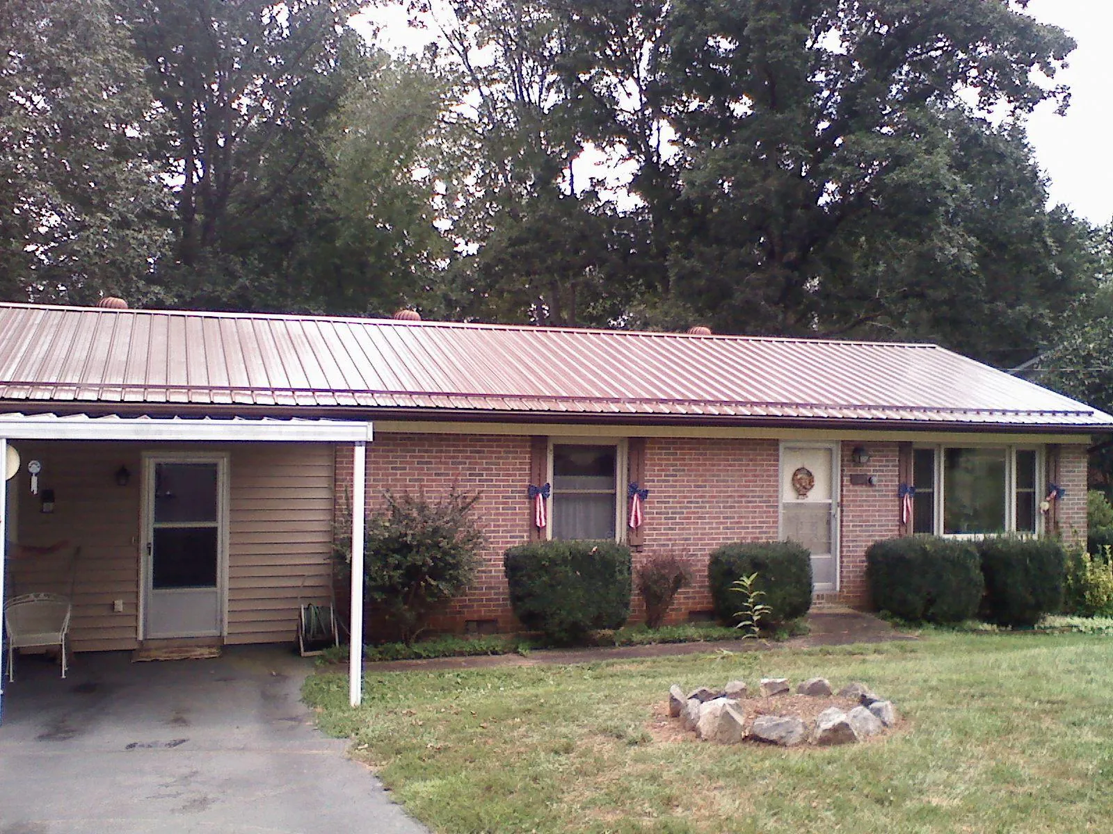Bronze metal roof and carport on a brick ranch home — Roof Repair work by our crew in Lattimore